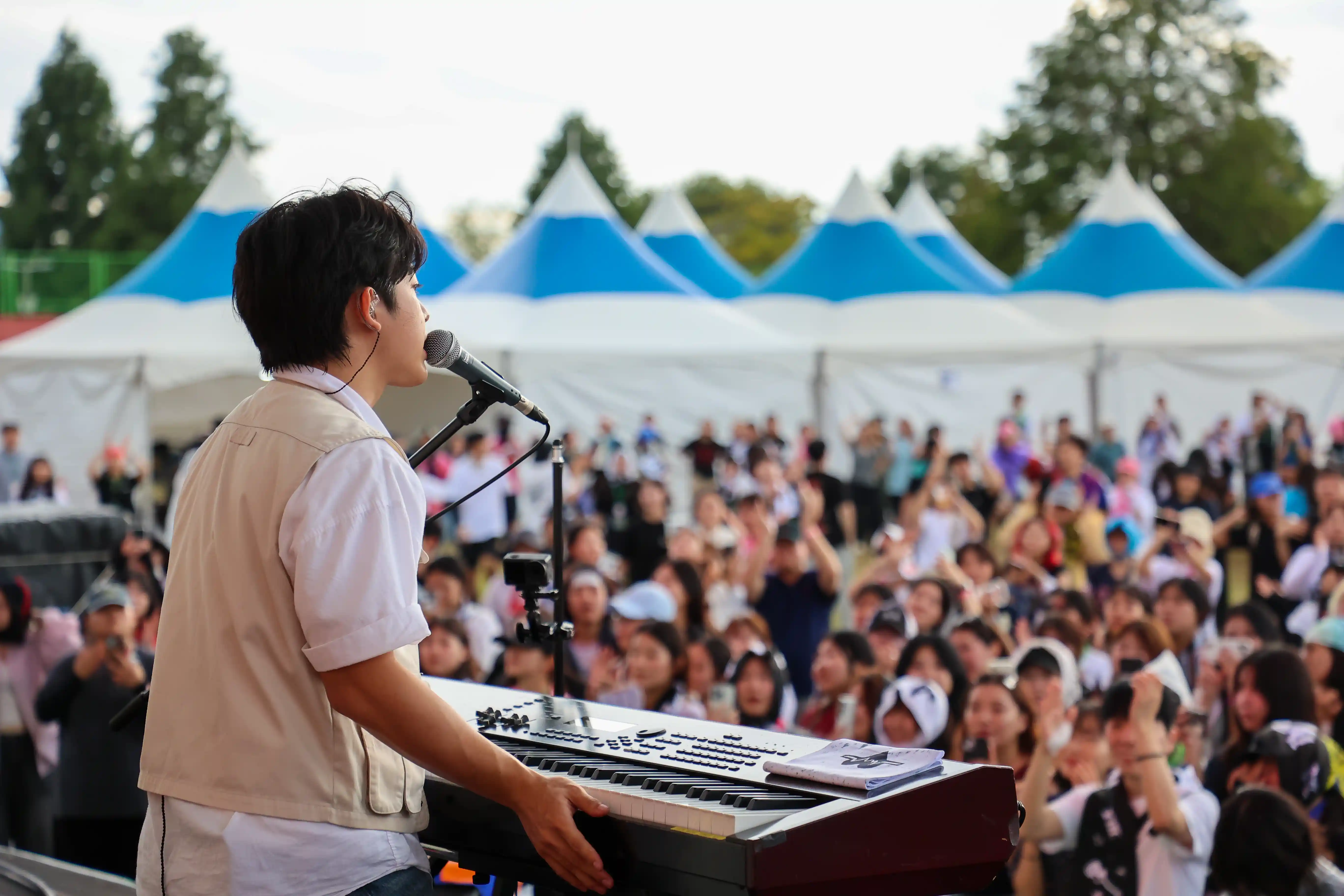 A performer at a keyboard facing the audience at the 2025 Busan International Rock Festival.